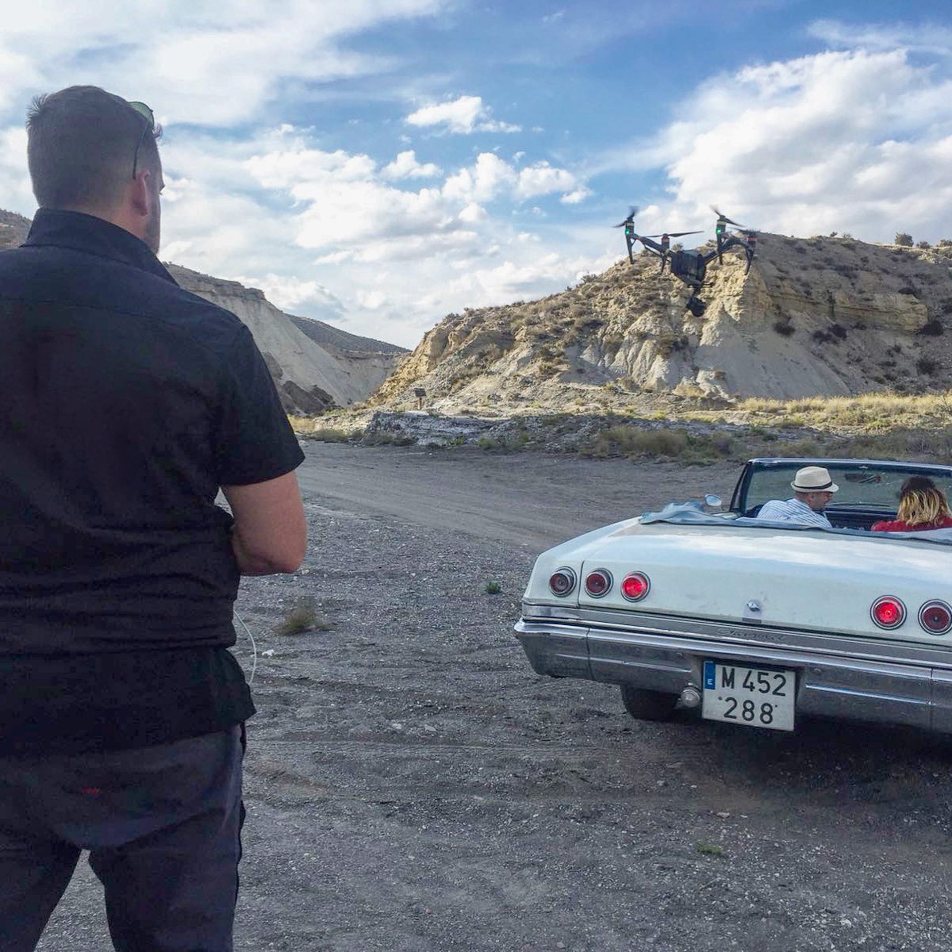 Operador de cámara durante un rodaje con coche clásico en el desierto de Almería